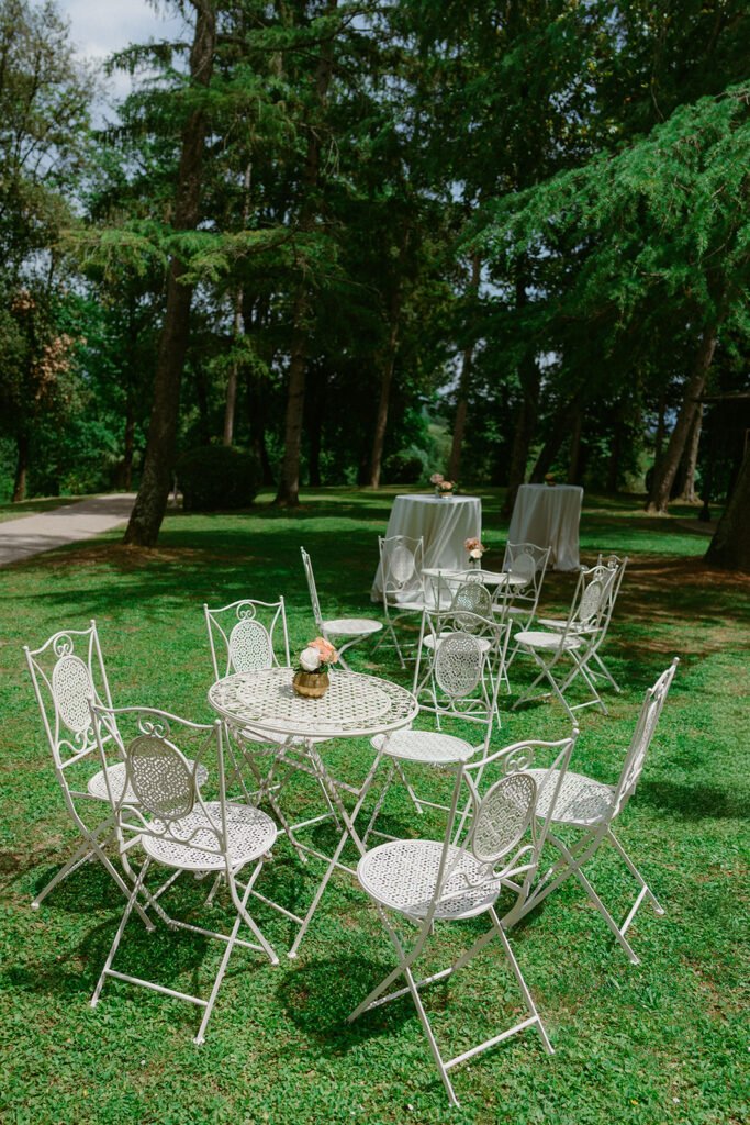 Garden lounge area with wrought iron tables prepared for the wedding aperitivo